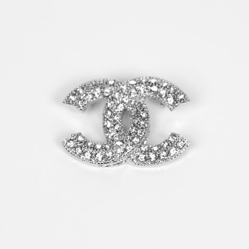 Brosje i sølvfarget metall - dobbel C-form med strass 4 x 3 cm